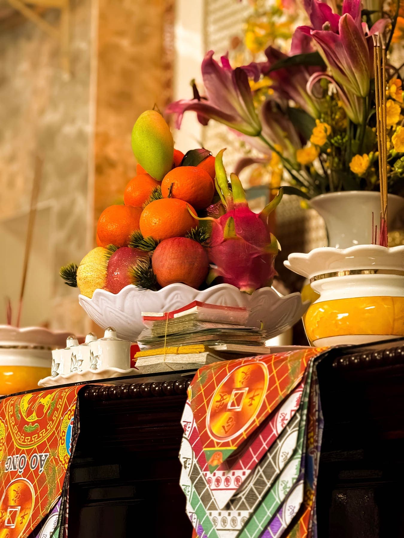 Mandarins, dragon fruit and a mango stacked on the ancestral altar